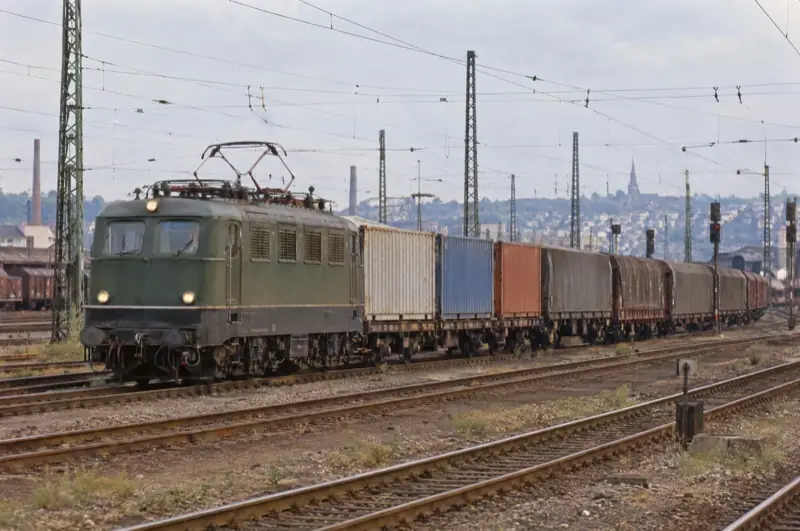 Grüne Elektrolok mit Containerwagen im Güterbahnhof